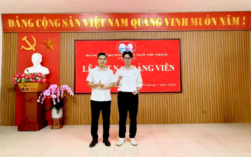 ồng chí Lý Duy Xuân – UVBTV, Trưởng Ban Tuyên giáo Huyện ủy, Giám đốc Trung tâm Chính trị huyện trao Quyết định kết nạp đảng viên cho học sinh Phạm Nguyễn Thái Bình