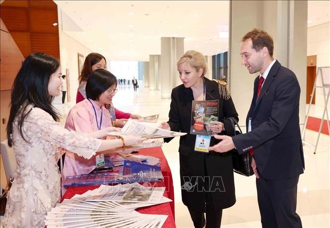 Đại biểu quốc tế tham quan, tìm hiểu các ấn phẩm báo chí của Thông tấn xã Việt Nam. (Ảnh: Phương Hoa/TTXVN)